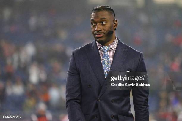 Analyst and former NFL quarterback Robert Griffin III broadcasts on the field prior to an NFL football game between the New England Patriots and the...