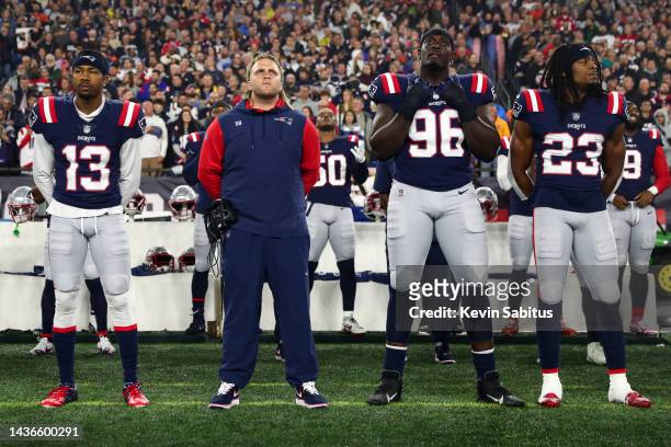 Jack Jones, outside linebackers coach Stephen Belichick, Sam Roberts, and Kyle Dugger of the New England Patriots stand on the sidelines during the...