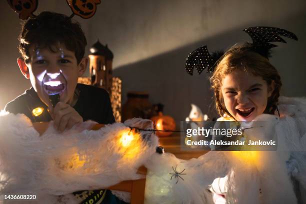 kinder machen an halloween gruselige grimassen vor der kamera - head torch stock-fotos und bilder