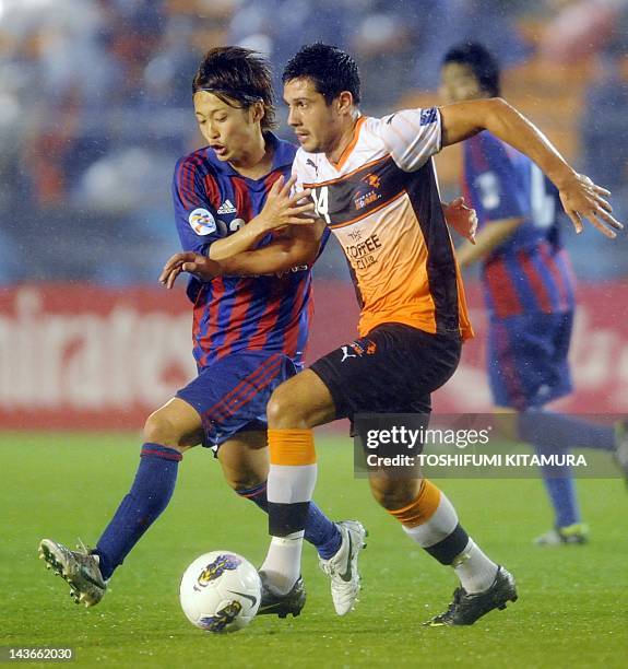 Tokyo defender Kenta Mukuhara fights for the ball with Brisbane Roar forward Nicholas Fitzgerald during their AFC Champions League Group F match in...