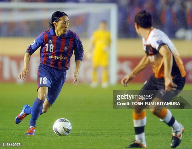 Tokyo midfielder Naohiro Ishikawa dribbles the ball in front of Brisbane Roar defender Shane Stefanutto during their AFC Champions League Group F...