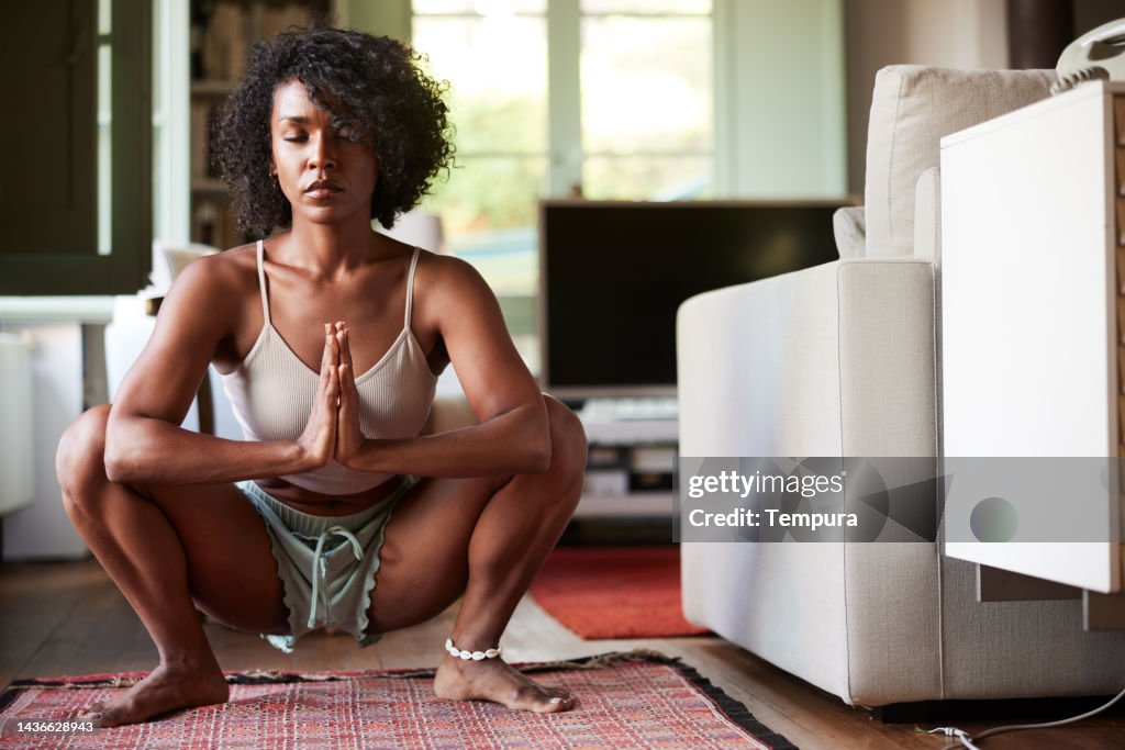 Deep meditation in the Garland pose (Malasana) yoga prayer squat position