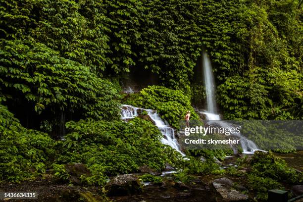 happy woman enjoying by the waterfall in nature. - lombok bildbanksfoton och bilder