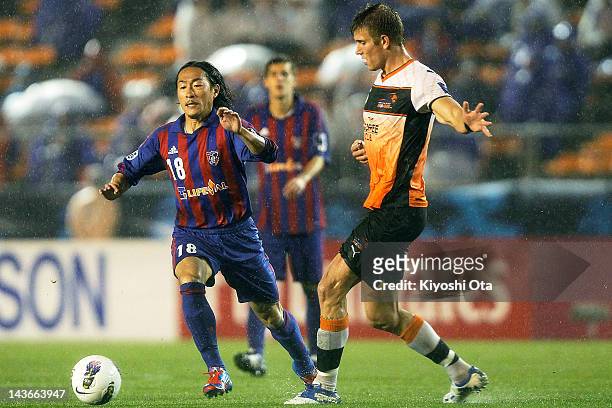 Naohiro Ishikawa of FC Tokyo and Erik Paartalu of the Roar contest the ball during the AFC Asian Champions League Group F match between FC Tokyo and...