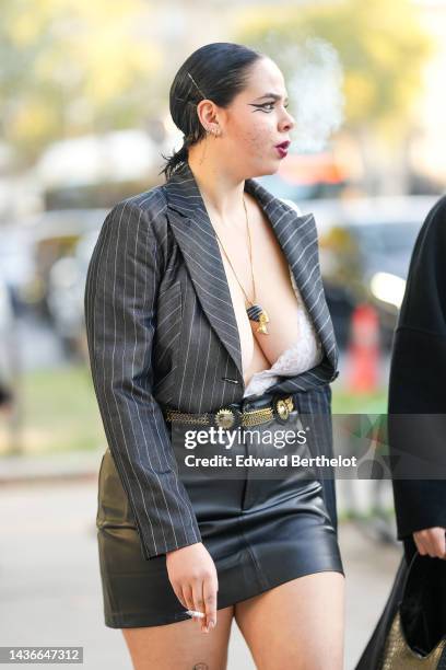 Guest wears silver hair clips, gold earrings, a black striped print pattern cropped blazer jacket, a beige lace print pattern V-neck body, a black...