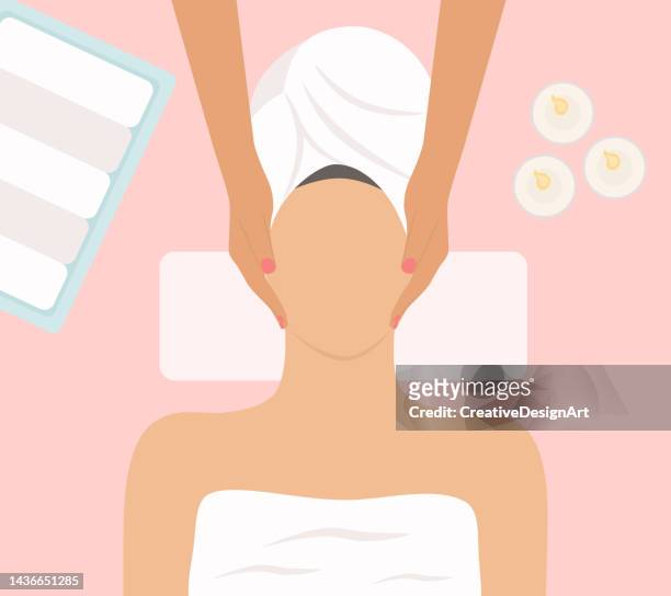 woman receiving facial massage and skin care treatment at spa center - bathrobe stock illustrations