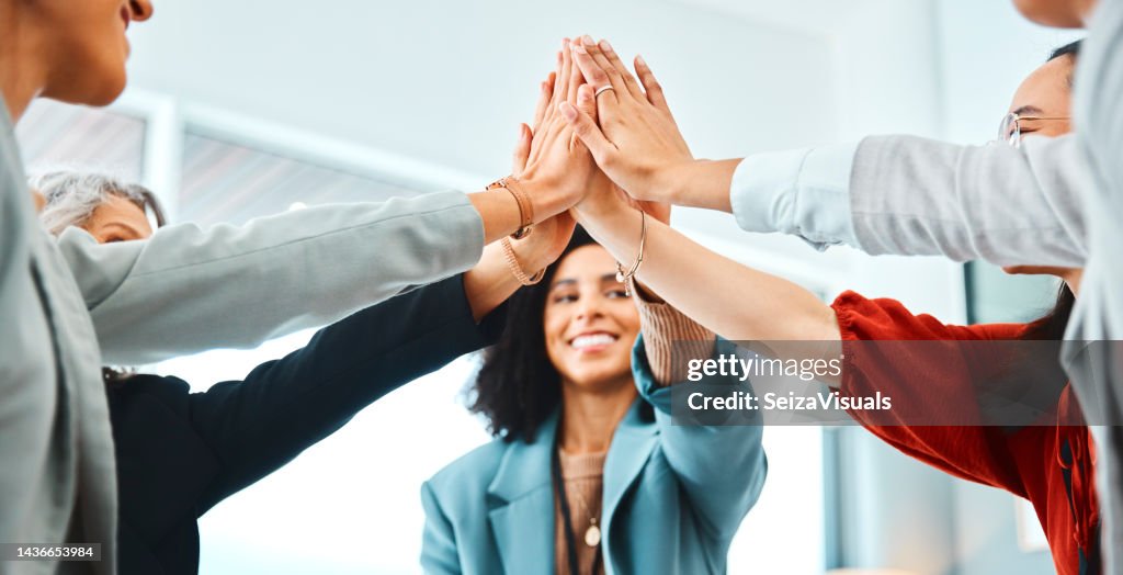 Hands, high five and team building in office with workers connecting in support of success and fun. Teamwork, collaboration and hand in solidarity of community goal, vision and mission for success