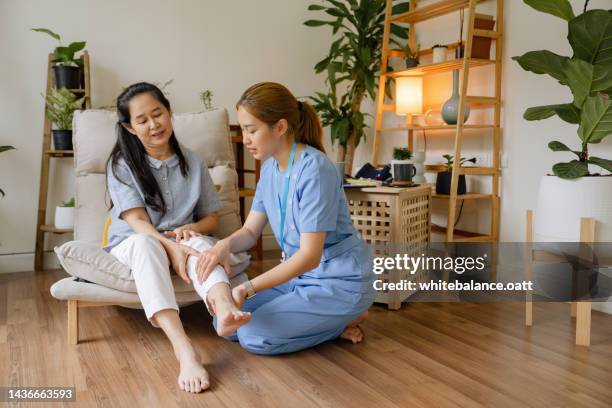 senior adult doing physiotherapy supported by therapist - physiotherapy asian stock pictures, royalty-free photos & images