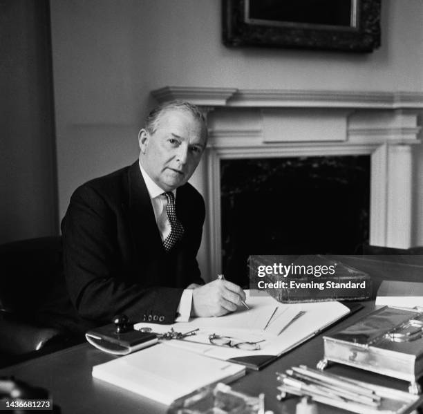British politician Selwyn Lloyd , Conservative Party Chancellor of the Exchequer, seated behind his desk at the Treasury building in London, England,...