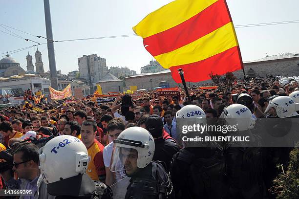 Turkish riot policemen make a barricade as Galatasaray football team fans gather on Taksim Square to protest against the Turkish Football Federation...