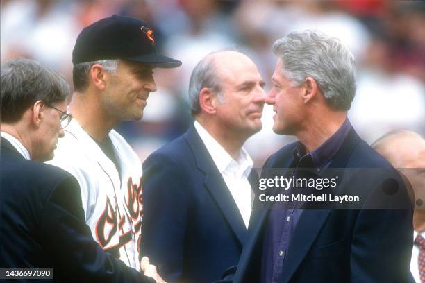 July 13: Cal Ripken Jr. #8 and President Bill Clinton shake hands before of the Baltimore Orioles looks on before a baseball game against the...