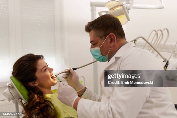 young woman at dentist's office replacing fillings - mensentong stockfoto's en -beelden