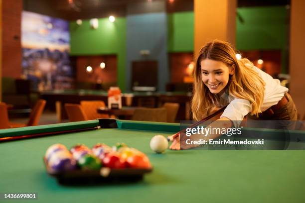 young woman aiming at pool balls - billiard ball game stock pictures, royalty-free photos & images