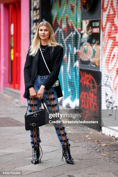 Nina Sieber wearing a black blazer by The Frankie Shop, a black top by Balenciaga - Breuninger, blue denim belt buckle jeans by Marina Hoermanseder,...