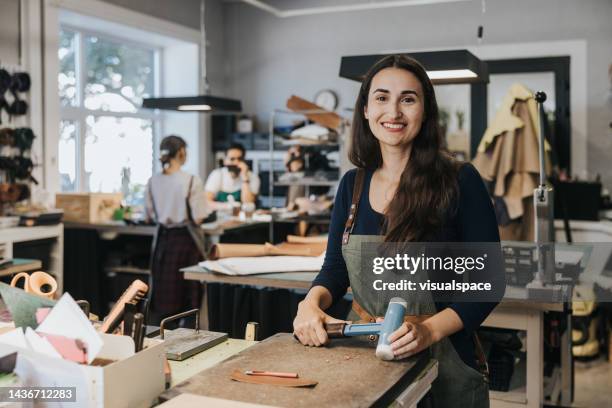 artisane positive dans un atelier de design de petite entreprise - maroquinerie photos et images de collection