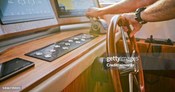 man's hands on steering wheel - boat steering wheel stock pictures, royalty-free photos & images