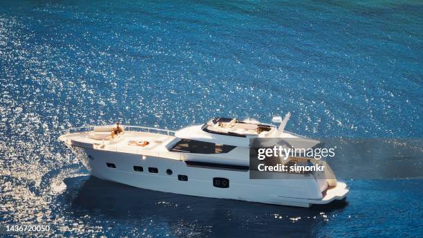 paar sonnenbaden auf yacht - segeljacht stock-fotos und bilder