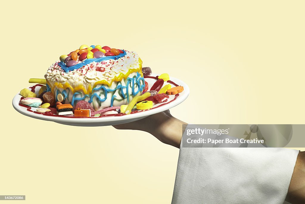 Hand holding a colorful messy home made cake