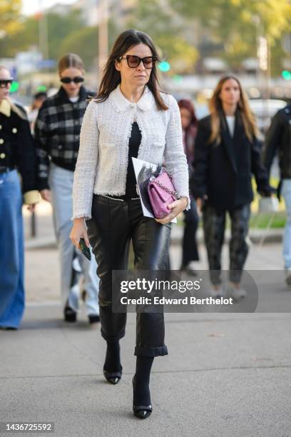 Guest wears black sunglasses, a white tweed jacket, a black t-shirt, black shiny leather pants, black tights, a white pearls belt, a purple velvet...