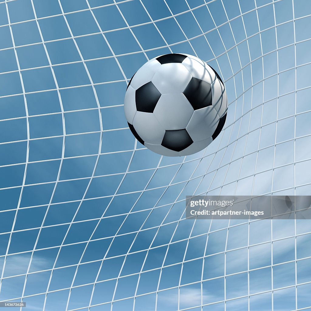 Soccer ball flying into a goal