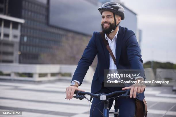 junger geschäftsmann fährt nach der arbeit fahrrad und lächelt - cycling helmet stock-fotos und bilder
