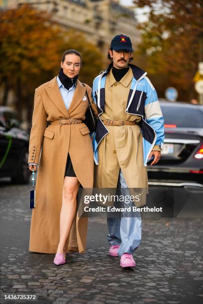 Influencers Young Emperors are seen. A guest wears a black zipper high neck pullover, a pale blue shirt, a black short skirt, a brown belted long...