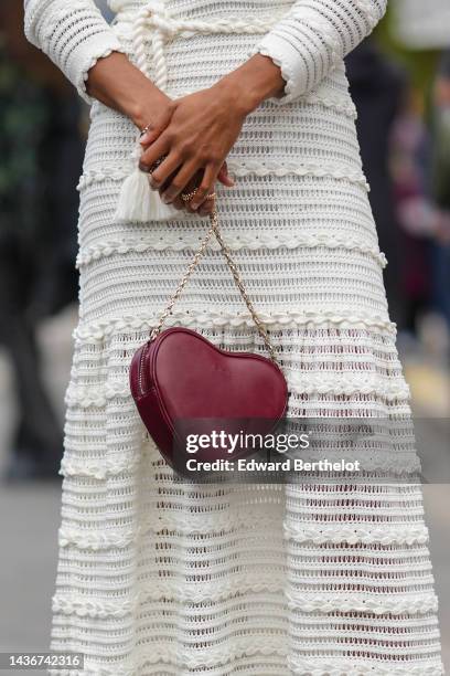 Guest wears a white striped print pattern / embroidered lace print pattern long sleeves / long dress, gold Clash rings from Cartier, a burgundy shiny...