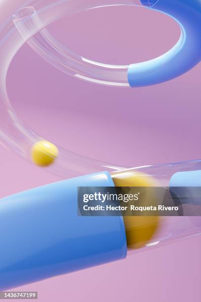 yellow balls passing through transparent and blue plastic tube on purple background - digital fulfillment stock-fotos und bilder