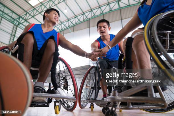 teamwork of basketball player wheelchair basketball players doing fist bump together. - wheelchair basketball team stock pictures, royalty-free photos & images