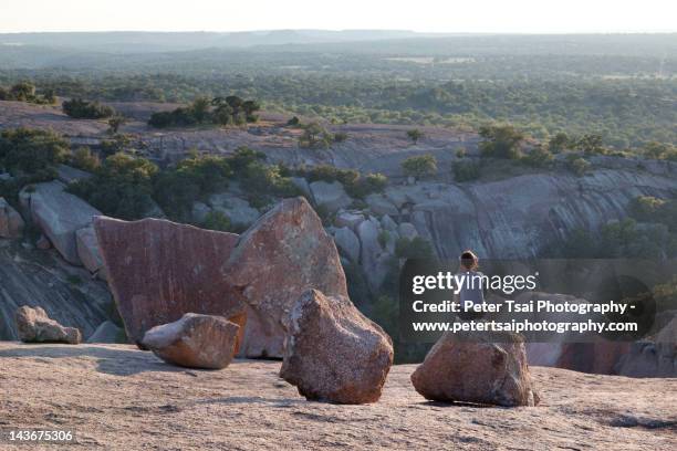 woman sitting on top of enchanted rock - austin texas sunset stock pictures, royalty-free photos & images