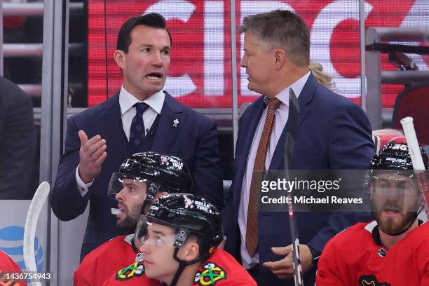 Head coach Luke Richardson of the Chicago Blackhawks talks with assistant coach Kevin Dean against the Detroit Red Wings during the second period at...
