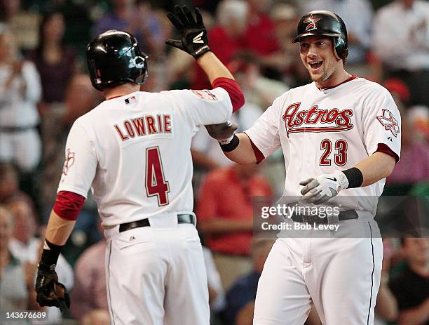 Chris Johnson of the Houston Astros gets a high five from Jed Lowrie after hitting a three run home run against the New York Mets in the second...