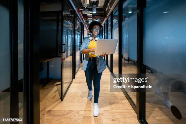 glückliche it-technikerin, die mit ihrem laptop im büro arbeitet - female programmer stock-fotos und bilder