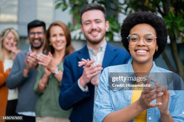 portrait of a happy business team applauding outdoors - applauding staff stock pictures, royalty-free photos & images