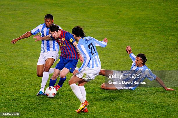 Lionel Messi of FC Barcelona duels for the ball with Eliseu Pereira , Sergio Sanchez and Martin Gaston Demichelisof Malaga CF duels for the ball with...