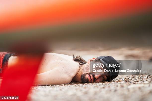 dead man lying on the beach after having an accident in the water. - coastal deprivation stock pictures, royalty-free photos & images