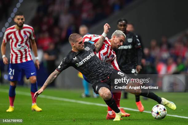 Robert Andrich of Bayer 04 Leverkusen battles for possession with Antoine Griezmann of Atletico Madrid during the UEFA Champions League group B match...