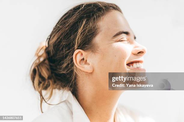 healthy young woman laughing against the sun - ear stockfoto's en -beelden