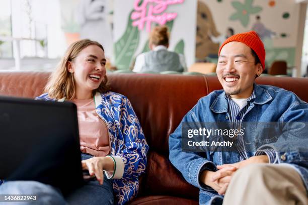 two businesspeople working together on a laptop in an office - hipster office stock pictures, royalty-free photos & images