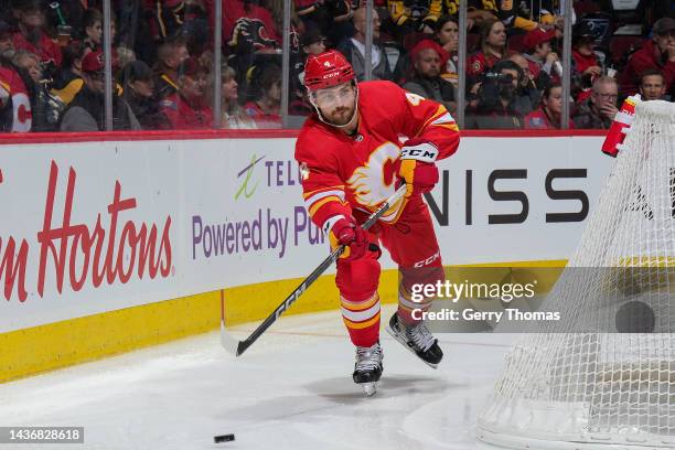 Rasmus Andersson of the Calgary Flames passes the puck behind the net against the Pittsburg Penguins at Scotiabank Saddledome on October 25, 2022 in...