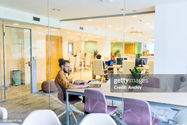 young man on a meeting in a hybrid office - hot desking stock pictures, royalty-free photos & images