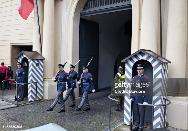 guardias marchan a través de la puerta en la ceremonia de cambio de guardia del castillo de praga - hradcany castle fotografías e imágenes de stock