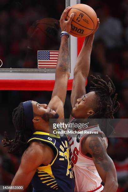 Isaiah Jackson of the Indiana Pacers blocks a dunk attempt by Ayo Dosunmu of the Chicago Bulls during the first half at United Center on October 26,...