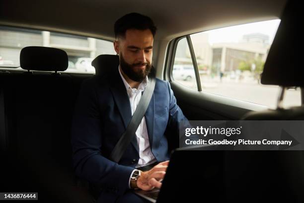 geschäftsmann, der auf einem laptop arbeitet, während er auf dem rücksitz eines taxis fährt - businessman taxi stock-fotos und bilder