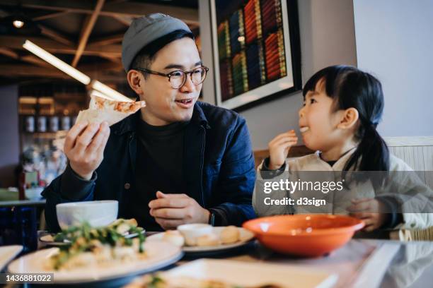 young asian father and lovely little daughter enjoying lunch in a restaurant. father and daughter chatting, spending time to a happy meal together. family eating out lifestyle. love and care concept - china tourist stock pictures, royalty-free photos & images