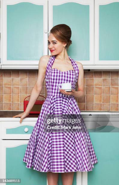 woman having cup of coffee in kitchen - bouffant hairdo stock pictures, royalty-free photos & images