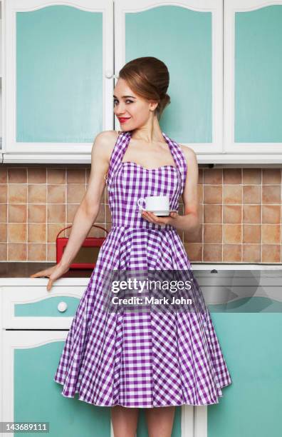 woman having cup of coffee in kitchen - vintage dress stock pictures, royalty-free photos & images