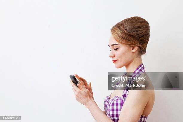 smiling woman using cell phone - beehive hair stock pictures, royalty-free photos & images