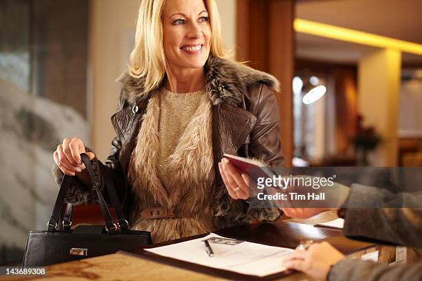 woman checking in to hotel - showing identification stock pictures, royalty-free photos & images