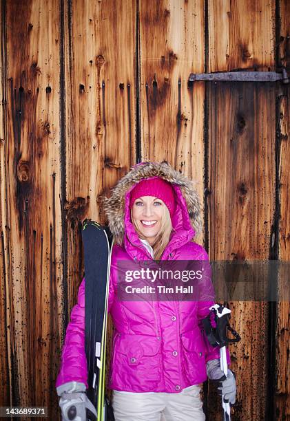 woman standing with skis and poles - tool shed wall spaces stockfoto's en -beelden